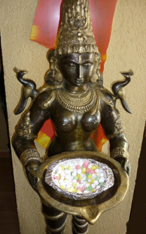 Eine Indische Statue reicht für den Heimweg noch eine Kleinigkeit - kandierte Kichererbsen